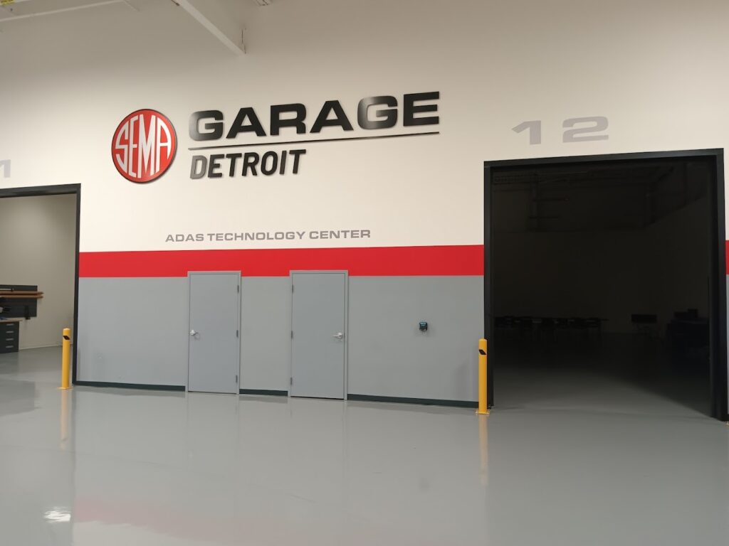 SEMA Garage Detroit ADAS Technology Center entrance with large logo and open workshop bays.