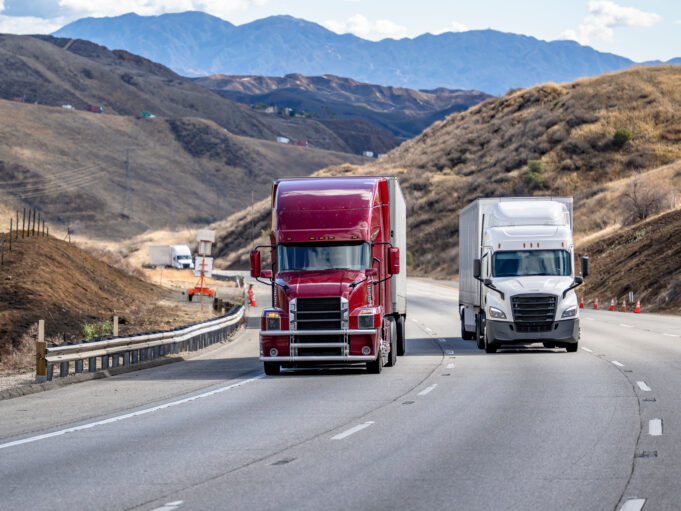 Two semi-trucks on a freeway.