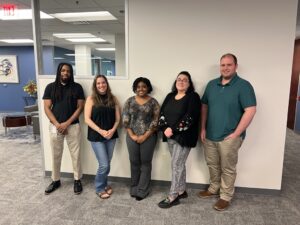 roup photo of MOTOR team members Mario Ogu, Andrea Forgue, Damikka Willis, Amy Wilson, and Kevin Mallock standing together in the office.